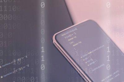 Smartphone con código y dígitos binarios en segundo plano. Guía para eliminar virus.